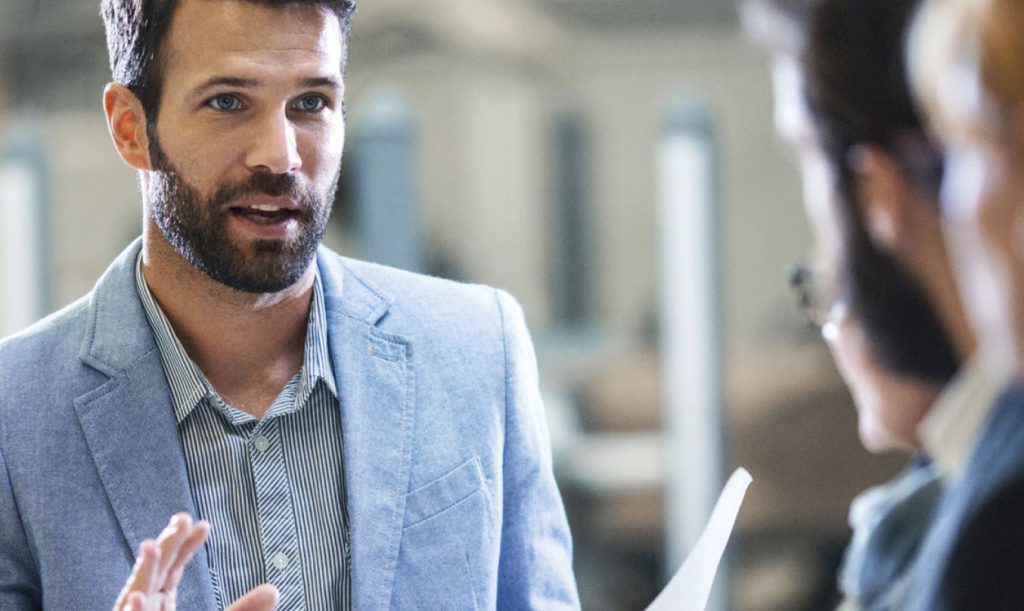 A consultant speaks in front of people opposite