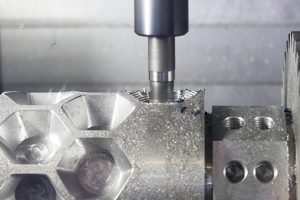Close-up of a machine drilling a hole in a piece of metal.